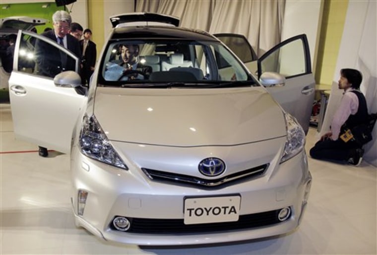Journalists inspect a wagon prototype of a Toyota Prius hybrid in Tokyo. Toyota plans to launch the seven-seater wagon type of its popular hybrid vehicle late April. 